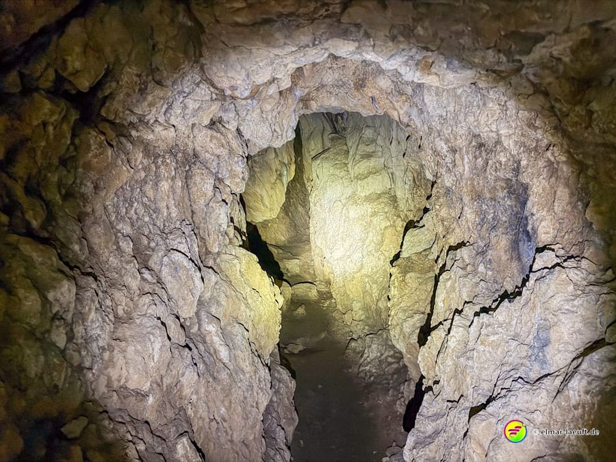 Blick in die enge Höhle, die Wände im Licht der Taschenlampe.