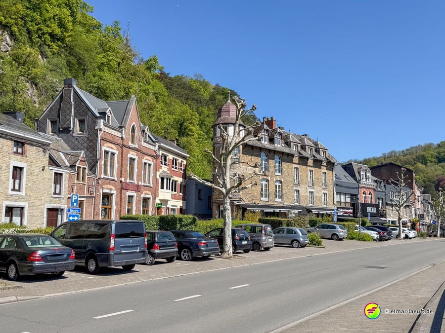 Dorfstraße mit dicht stehenden Häusern und parkenden Autos.