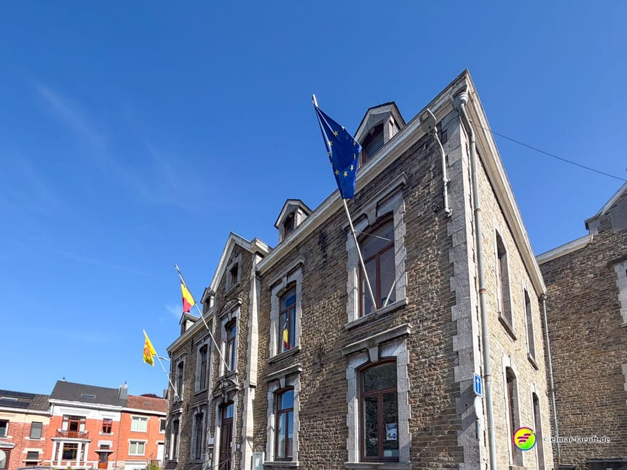 Bruchsteingebäude mit belgischer, wallonischer und europäischer Fahne.