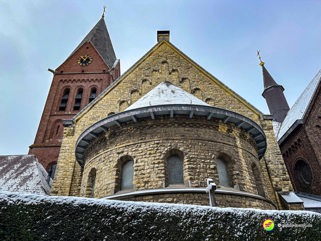 Laufen in Heerlen mit Blick auf eine historische Kirche, deren Dächer leicht mit Schnee bedeckt sind.